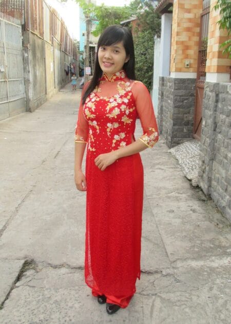 Áo dài lưới đỏ kết đá, hoa vàng